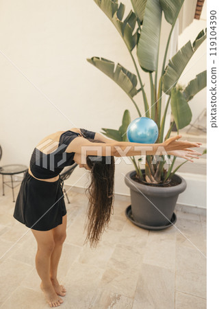 A Graceful Dance Pose with a Globe Amidst a Beautiful Tropical Setting and Vibrant Nature A Graceful Dance Pose with a Globe Amidst a Beautiful Tropical Setting and Vibrant Nature 119104390