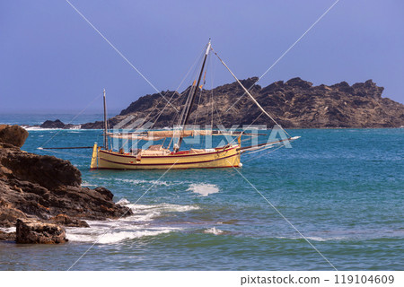 Traditional Sailboat in the Waters off the Coast of Cadaques, Spain Traditional Sailboat in the Waters off the Coast of Cadaques, Spain 119104609