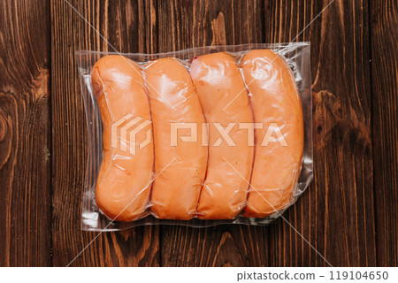 Vacuum-packed sausages on table, ideal for storage, transportation, or food photography purposes 119104650