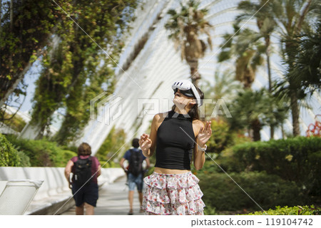 Stylish Young Woman Posing Joyfully in a Lush and Vibrant Botanical Setting during Daytime Stylish Young Woman Posing Joyfully in a Lush and Vibrant Botanical Setting during Daytime 119104742