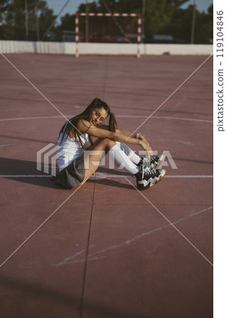 A Skater Girl Enjoys Some Relaxing Time on the Court, Embracing Her Passion for Skating 119104846