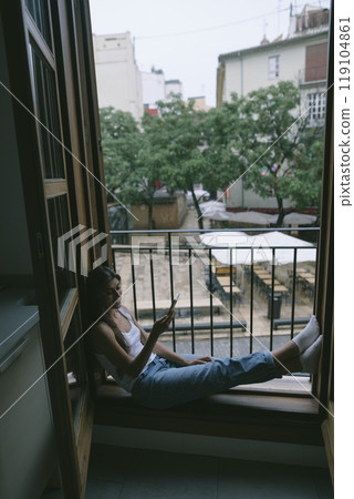 Taking a Moment to Relax by the Window in a Cozy, Comforting, and Inviting Space Taking a Moment to Relax by the Window in a Cozy, Comforting, and Inviting Space 119104861