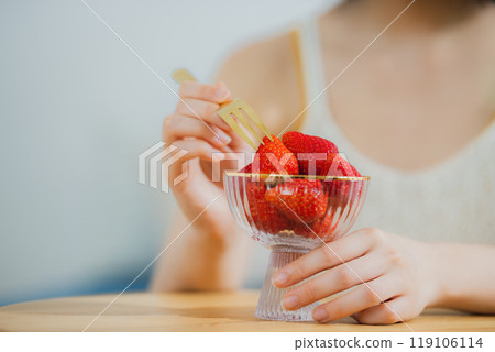 Woman eating strawberries 119106114