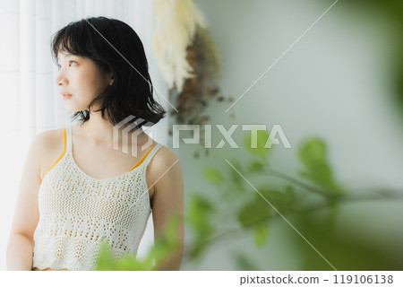 Woman opening curtain 119106138