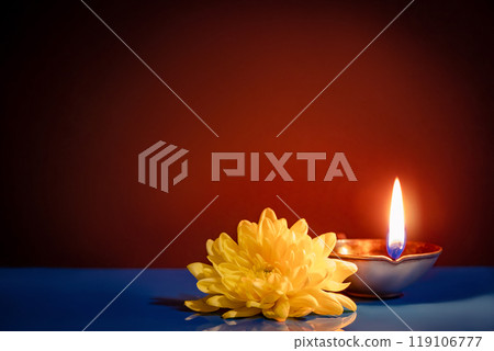 Happy Diwali. Traditional symbols of Indian festival of light. Burning diya oil lamps and flowers on red background. Copy space. 119106777