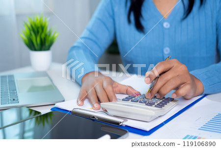 Businesswoman hand working with finances about cost and calculator and laptop with tablet on desk at office in morning light, Business accounting concept, Calculating or checking balance. Businesswoman hand working with finances about cost and calculator and laptop with tablet on desk at office in morning light, Business accounting concept, Calculating or checking balance. 119106890