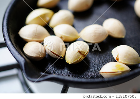 Dry roasting ginkgo nuts in a frying pan 119107505