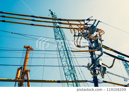 Electric wire protection covers around the construction site and cranes stretching into the blue sky a-4 warm colors 119108209