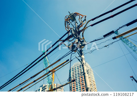 Electric wire protection covers around the construction site and cranes stretching into the blue sky c-4 warm colors 119108217
