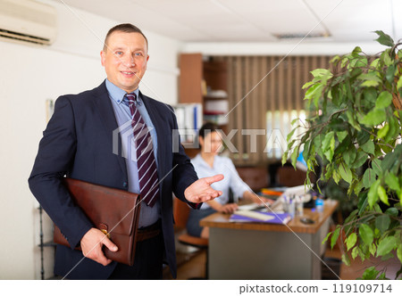 Friendly businessman meeting clients in office Friendly businessman meeting clients in office 119109714