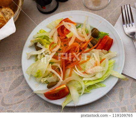 Vitamin salad of fresh vegetables, tomato, olives, onions is prepared for home snack Vitamin salad of fresh vegetables, tomato, olives, onions is prepared for home snack 119109765