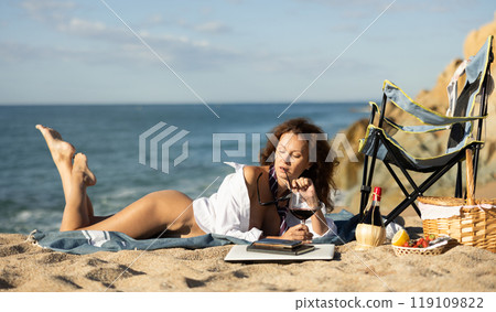 Seductive businesswoman posing near shoreline during picnic Seductive businesswoman posing near shoreline during picnic 119109822