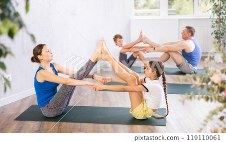 Happy mother and daughter practicing yoga poses 119110061