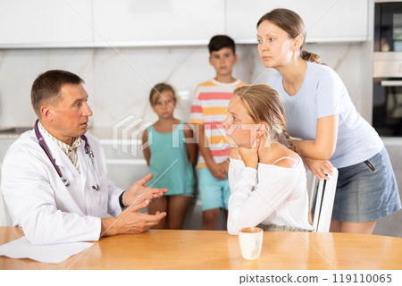 Family physician consults girl child with sore throat from large family at home Family physician consults girl child with sore throat from large family at home 119110065