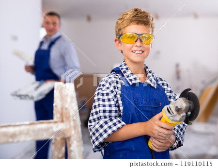 Portrait of positive young boy with angle grinder Portrait of positive young boy with angle grinder 119110115