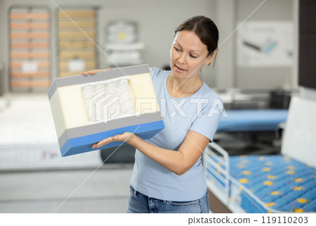 Girl chooses mattress filling in furniture store Girl chooses mattress filling in furniture store 119110203