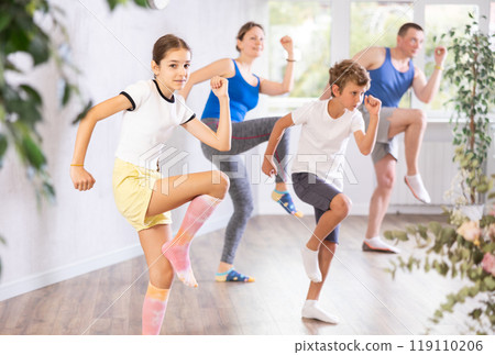 Parents together with their children learn how to dance salsa or boogie-woogie in dance class Parents together with their children learn how to dance salsa or boogie-woogie in dance class 119110206