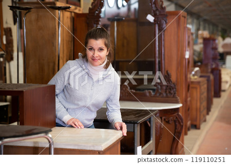 Satisfied woman chooses new furniture for home in the store Satisfied woman chooses new furniture for home in the store 119110251