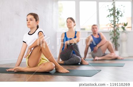 Family performing yoga exercises at yoga studio, family health concept 119110269