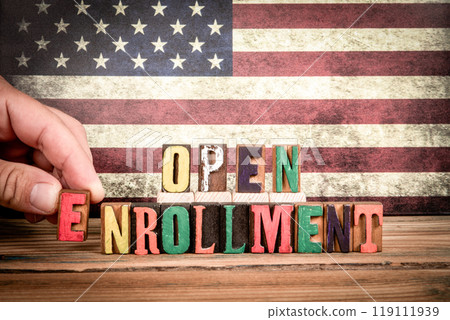 OPEN ENROLLMENT. Colorful letters of the alphabet on a wooden texture table 119111939