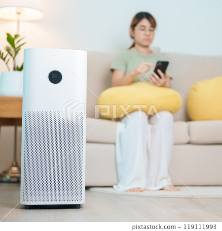 Air Purifier with woman relax and use smartphone on sofa. Purification system for filter and cleaning dust PM2.5 HEPA and virus in home. Allergy, Pure air, health, Wellness lifestyle and Air Pollution 119111993