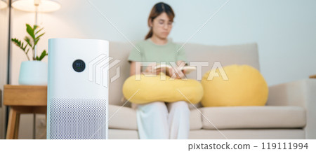 Air Purifier with woman read and relax on sofa. Purification system for filter and cleaning dust PM2.5 HEPA and virus in home. Allergy, Pure air, health lifestyle, Wellness life and Air Pollution Air Purifier with woman read and relax on sofa. Purification system for filter and cleaning dust PM2.5 HEPA and virus in home. Allergy, Pure air, health lifestyle, Wellness life and Air Pollution 119111994