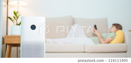 Air Purifier with woman relax and use smartphone on sofa. Purification system for filter and cleaning dust PM2.5 HEPA and virus in home. Allergy, Pure air, health, Wellness lifestyle and Air Pollution Air Purifier with woman relax and use smartphone on sofa. Purification system for filter and cleaning dust PM2.5 HEPA and virus in home. Allergy, Pure air, health, Wellness lifestyle and Air Pollution 119111995