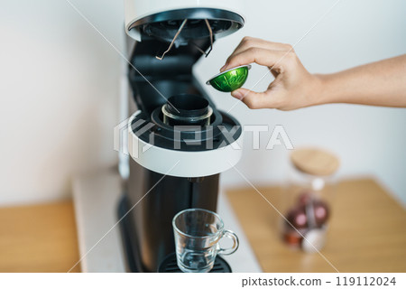 hand making Espresso Coffee by Coffee Maker Machine with Capsule of roasted coffee bean on wood table bar. Daily beverage drink at Home, Apartment and Office concept hand making Espresso Coffee by Coffee Maker Machine with Capsule of roasted coffee bean on wood table bar. Daily beverage drink at Home, Apartment and Office concept 119112024