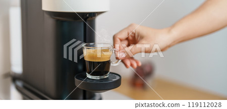 Espresso cup with steam and froth during Coffee making Coffee by Coffee Maker Machine on wood table bar. Cafe shop, Daily beverage drink at Home, Apartment and Office concept 119112028