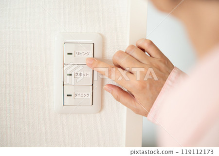 中年婦女按下公寓的電燈開關 119112173