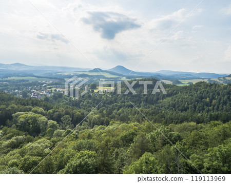 Panoramic view from sandstone rock lookout Jehla near Ceska Kamenice town. Summer landscape in Lusatian Mountains with green hills and mixed forest. Panoramic view from sandstone rock lookout Jehla near Ceska Kamenice town. Summer landscape in Lusatian Mountains with green hills and mixed forest. 119113969
