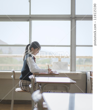 A female junior high school student studying at a window seat at school A female junior high school student studying at a window seat at school 119115190