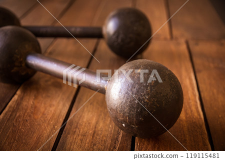 Old rusty dumbbells on wood background texture Old rusty dumbbells on wood background texture 119115481
