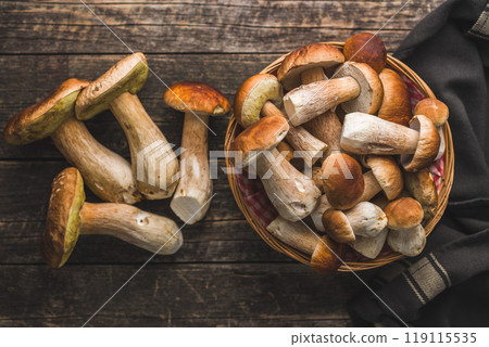 Fresh boletus mushrooms in basket on wooden table. Top view. 119115535