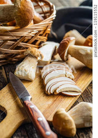 Fresh boletus mushrooms on cutting board on wooden table. 119115552