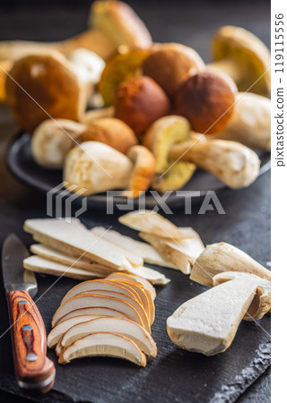 Fresh boletus mushrooms on cutting board on kitchen table. 119115556