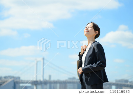 Business woman standing in the blue sky 119116985