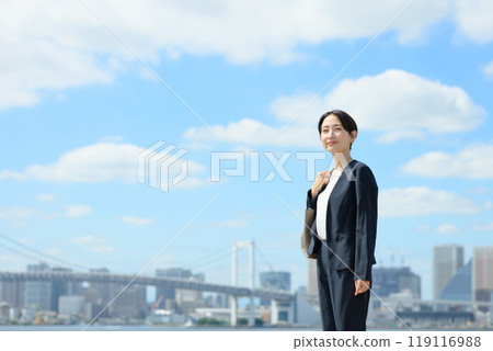Business woman standing in the blue sky 119116988