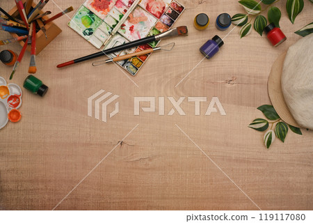 Variety of art supplies including paint brushes, watercolor paint and palette on wooden background Variety of art supplies including paint brushes, watercolor paint and palette on wooden background 119117080