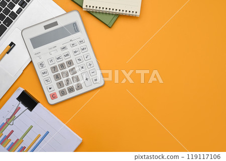 A calculator, laptop, financial reports and notepad on yellow background with space A calculator, laptop, financial reports and notepad on yellow background with space 119117106