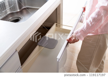 中年婦女看著廚房櫥櫃儲藏室 中年婦女看著廚房櫥櫃儲藏室 119117197