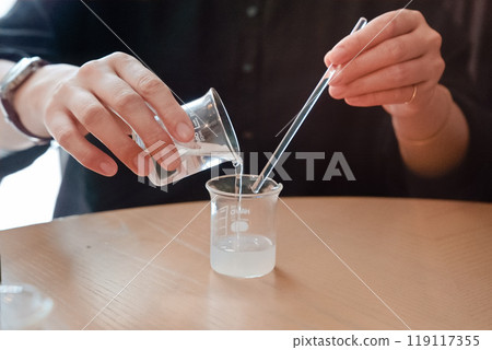 A woman mixing essential oils to make perfume 01 A woman mixing essential oils to make perfume 01 119117355