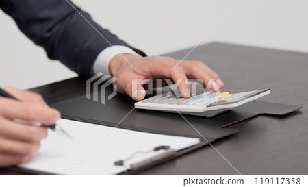 一位商人計算存摺金額的手 一位商人計算存摺金額的手 119117358