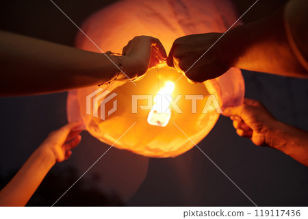 Young Couple Launching Lantern In The Sky 119117436