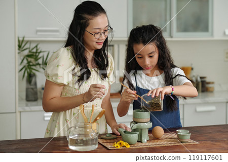 Mom Teaching Her Daughter To Make Tea Mom Teaching Her Daughter To Make Tea 119117601