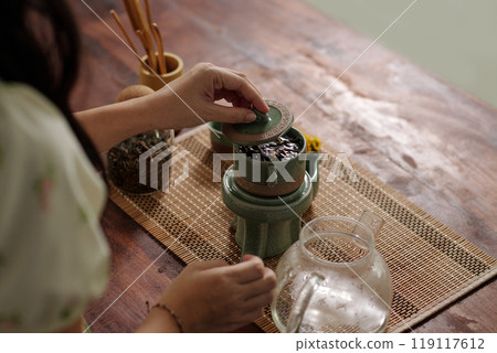 Woman Brewing Green Tea At Table 119117612