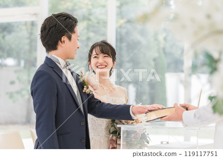 新娘和新郎在婚禮上雙手合十地對著聖經發誓 119117751