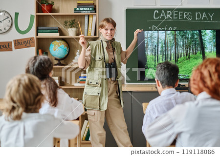 Female forester showing short film about her job to teen boys and girls during vocational guidance class at school 119118086