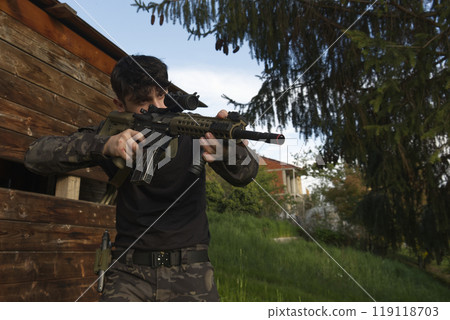 a young soldier stationed behind a shed 119118703