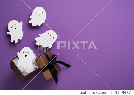 Cute paper Halloween ghosts floating out of a gift box on purple background. Background for Halloween cards, banners, invitations. Place for your text. 119119477